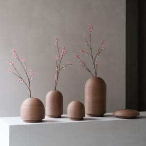 XLBoom Nova Vases in mocha finish in all shapes with pink blossom branches on minimalist pedestal